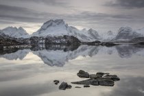 Reflexão da cordilheira coberta de neve em lago calmo, Noruega — Fotografia de Stock