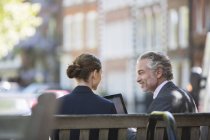 Business people talking on urban bench — Stock Photo