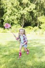 Menina brincando com rede de borboleta no quintal — Fotografia de Stock