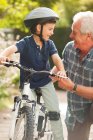 Abuelo enseñando nieto a montar en bicicleta - foto de stock