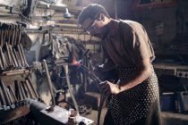 Schmied erhitzt Metall mit Blasbrenner in Schmiede — Stockfoto