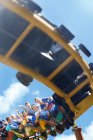 Друзья катаются на американских горках в солнечном парке развлечений — стоковое фото