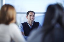 Empresário adulto bem sucedido sorrindo em reunião — Fotografia de Stock