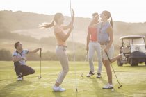 Women high fiving on golf course — Stock Photo