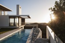 Modern house overlooking beach at sunset — Stock Photo