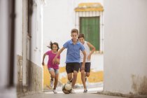 Дети играют в футбол в переулке — стоковое фото