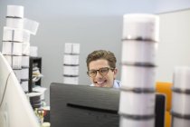 Retrato de un hombre de negocios sonriente rodeado de cajas de CD - foto de stock
