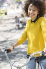 Retrato sorridente mulher na bicicleta no parque — Fotografia de Stock