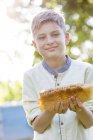 Portrait confident boy holding fresh honeycomb — Stock Photo