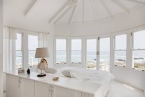 Інтер'єр білої спальні з видом на океан — стокове фото