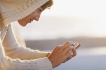 Seitenansicht einer Frau, die ihr Handy draußen benutzt — Stockfoto