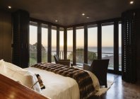 Розкішна спальня з видом на океан на заході сонця — стокове фото