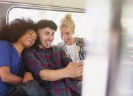 Amici giocherelloni scattare selfie facendo facce sul bus — Foto stock