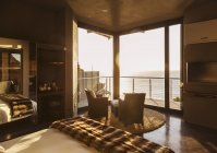 Dormitorio de lujo con vistas al océano al atardecer - foto de stock