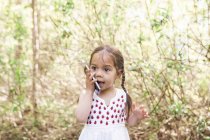 Девочка Тоддлера разговаривает по мобильному телефону в парке — стоковое фото