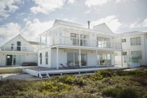 Casa de playa blanca bajo nubes - foto de stock