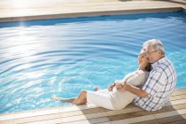 Старша пара розслабляється біля басейну — стокове фото
