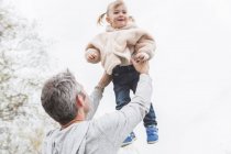 Pai levantando criança filha sobrecarga — Fotografia de Stock