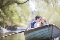 Casal sentado em barco a remos no rio — Fotografia de Stock