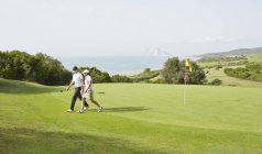 Side view of couple walking on golf course — Stock Photo
