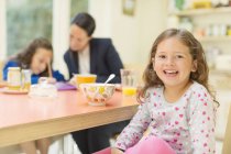 Portrait enthusiastic girl at breakfast table — Stock Photo