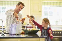 Familie entsaftet Gemüse in Küche — Stockfoto
