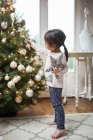 Toddler girl decorating Christmas tree — Stock Photo