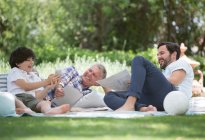 Mehrgenerationenmänner entspannen sich auf Decke im Hinterhof — Stockfoto