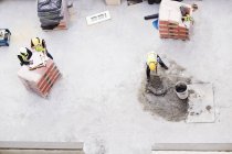 Visão geral dos trabalhadores da construção civil que colocam concreto no canteiro de obras — Fotografia de Stock