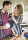 Fidanzata alimentazione fidanzato croissant in cucina — Foto stock