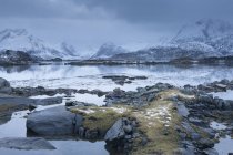 Schneebedeckte Berge hinter kalter, ruhiger Bucht, erhabene Inseln, Norwegen — Stockfoto