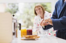 Woman watching husband crack egg in kitchen — Stock Photo