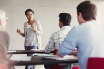 Teacher speaking to students in adult education classroom — Stock Photo