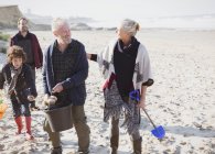 Multi-generation family clam digging on beach — Stock Photo