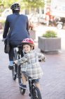 Портрет улыбающийся мальчик на тандеме велосипеда с отцом бизнесмена — стоковое фото