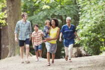 Familia multigeneracional caminando en el bosque - foto de stock