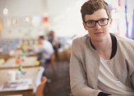 Portrait confident man with eyeglasses in cafe — Stock Photo