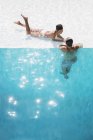 Молодые пары расслабляются в бассейне — стоковое фото