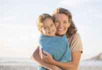 Grandmother and granddaughter hugging on beach — Stock Photo