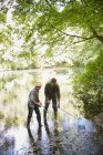 Padre e hijo pescando con redes en estanque - foto de stock