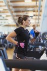 Konzentrierte Frau läuft im Fitnessstudio auf Laufband — Stockfoto