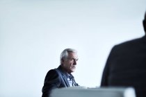 Ernsthafter Senior-Geschäftsmann hört bei Treffen zu — Stockfoto