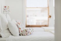 Vue rapprochée des oreillers colorés sur lit blanc — Photo de stock