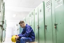 Worker holding hard-hat in locker room — Stock Photo