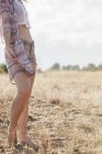 Boho donna in piedi nel soleggiato campo rurale — Foto stock