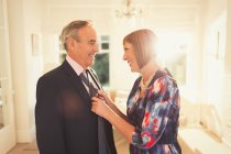Lächelnde Ehefrau bindet Mann die Krawatte — Stockfoto