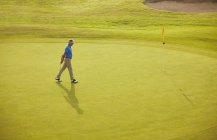 Vista lateral do homem caucasiano caminhando no campo de golfe — Fotografia de Stock
