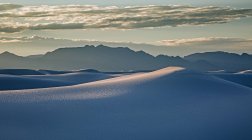 Silhouetted mountains behind tranquil white sand dune, White Sands, New Mexico, United States — Stock Photo