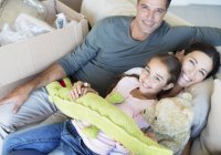 Portrait de famille souriante avec peluches sur canapé — Photo de stock