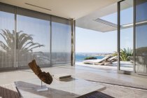 Modern living room and patio overlooking ocean — Stock Photo